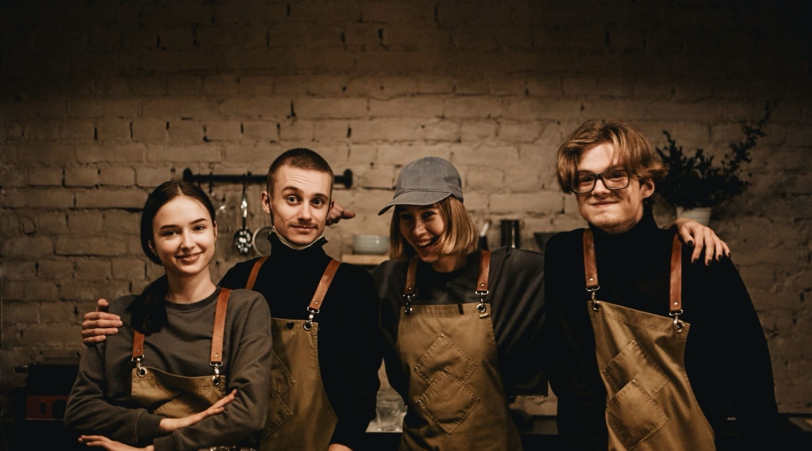 A front-of-house team in aprons standing together behind the counter